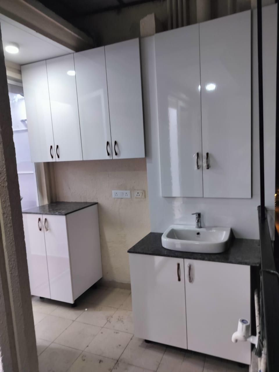 Utility and wash area with white storage cabinets