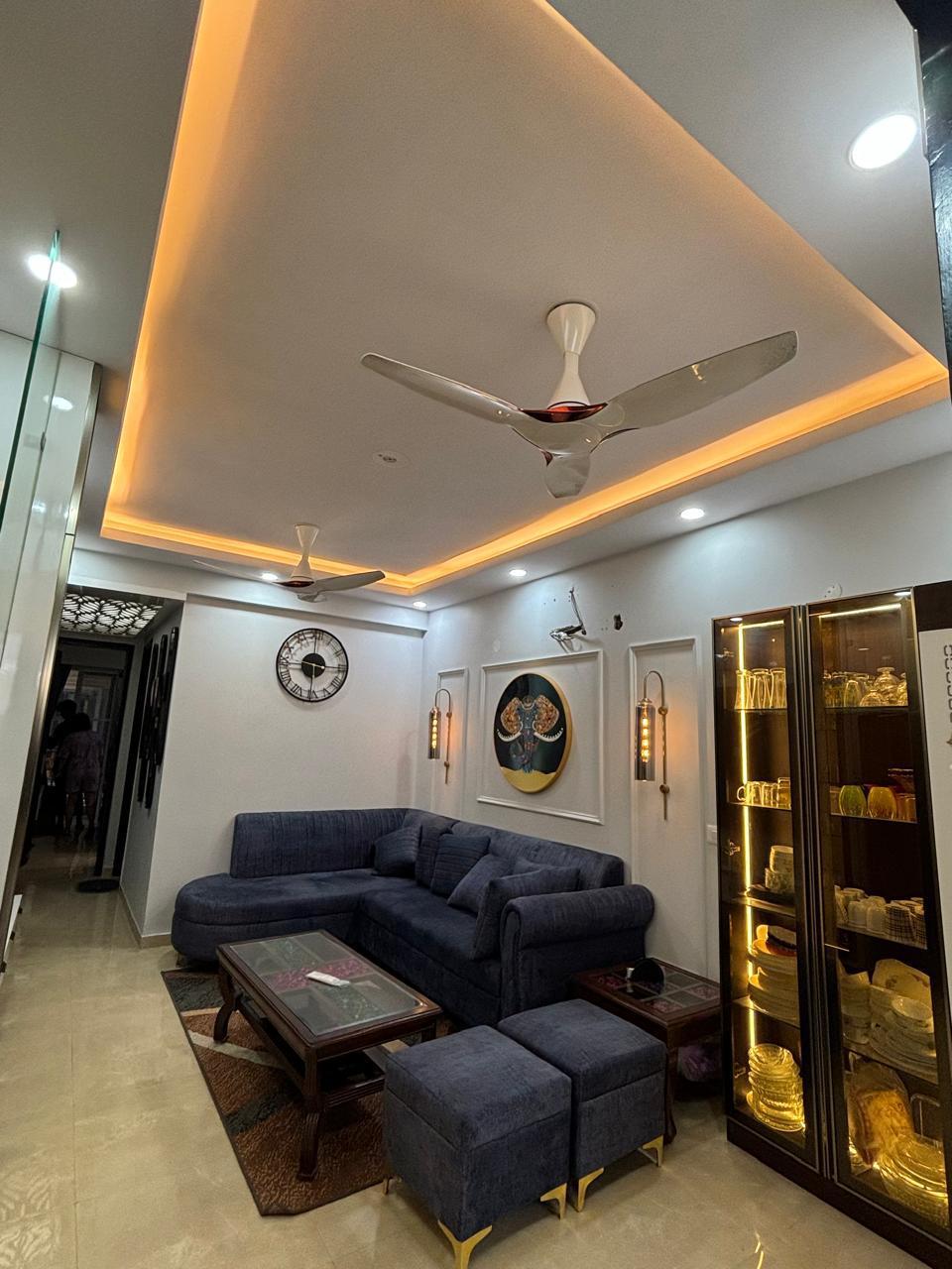 Living room with chandelier, sectional sofa, and crockery unit