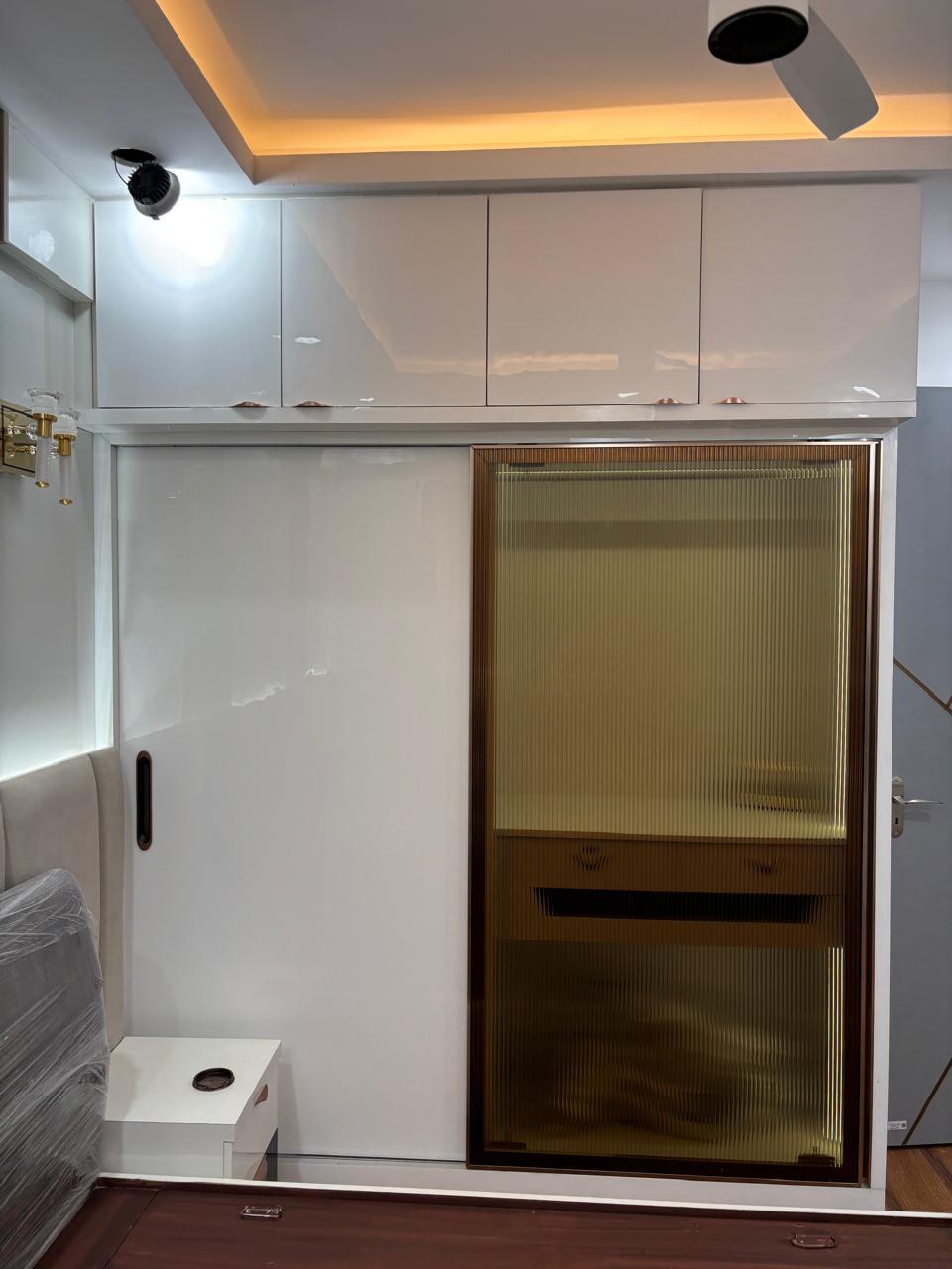 Glossy white modular wardrobe with fluted glass shutter